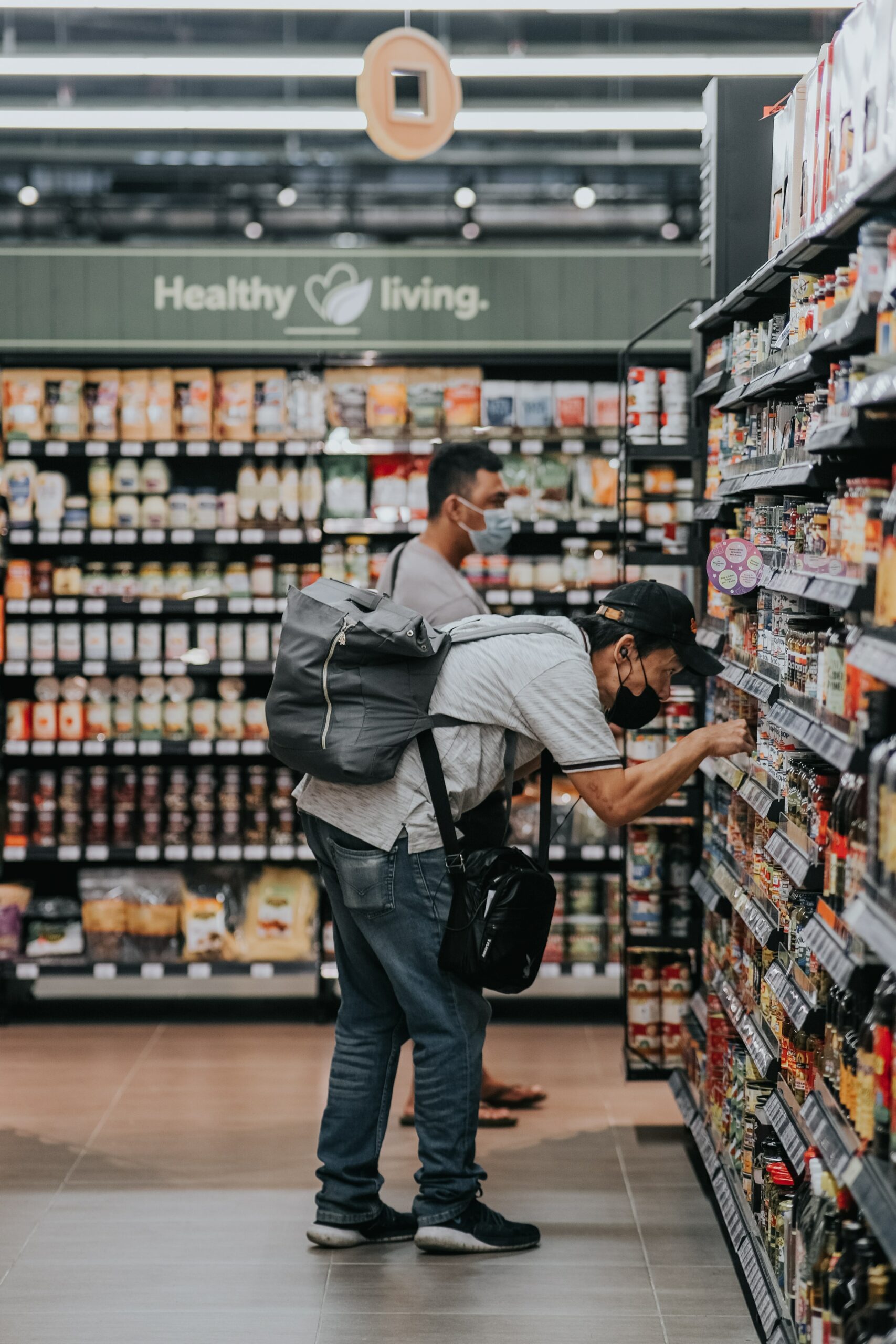 A guy is electing a products in a supermarkert shelf