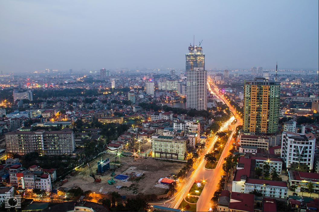 Skyline of Hanoi by night with its roads, buidling, construction sites and the lake in the background
