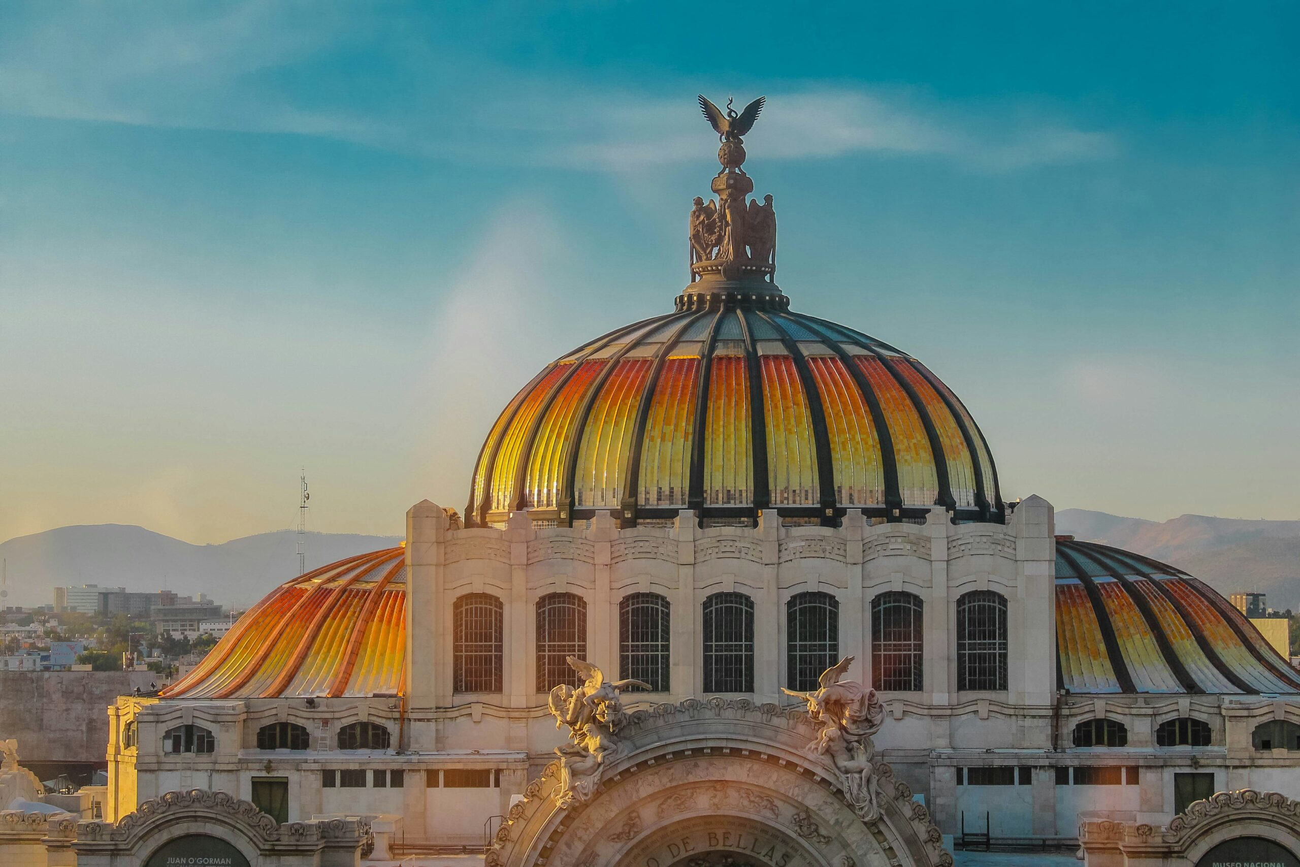A large building in Mexico with a colorful dome on top of it