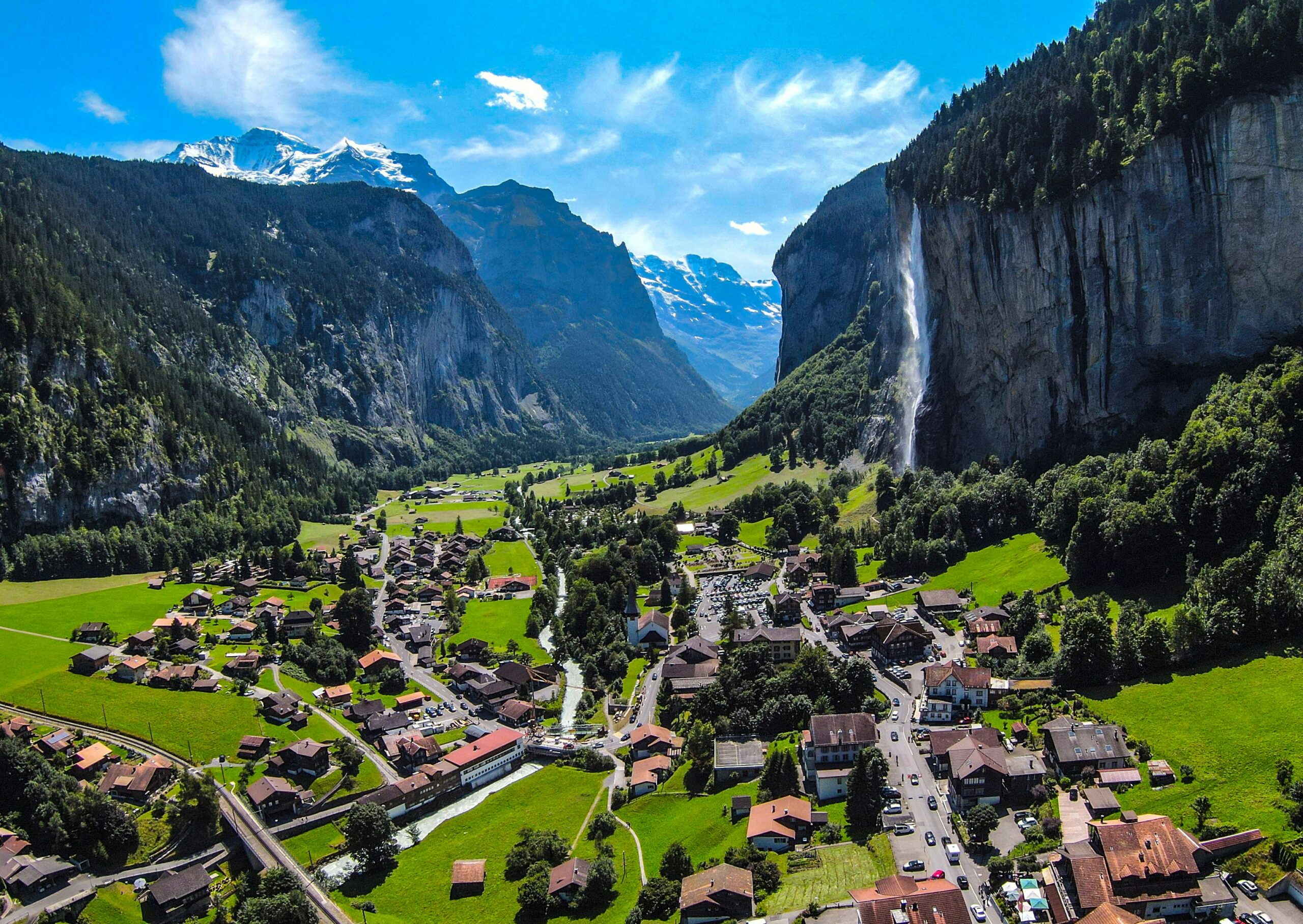 Switzerland Consumer Health and Pharma Market Overview: 2040 Growth Outlook houses on green grass field near mountain under blue sky during daytime, Lauterbrunnen, Berne, Switzerland