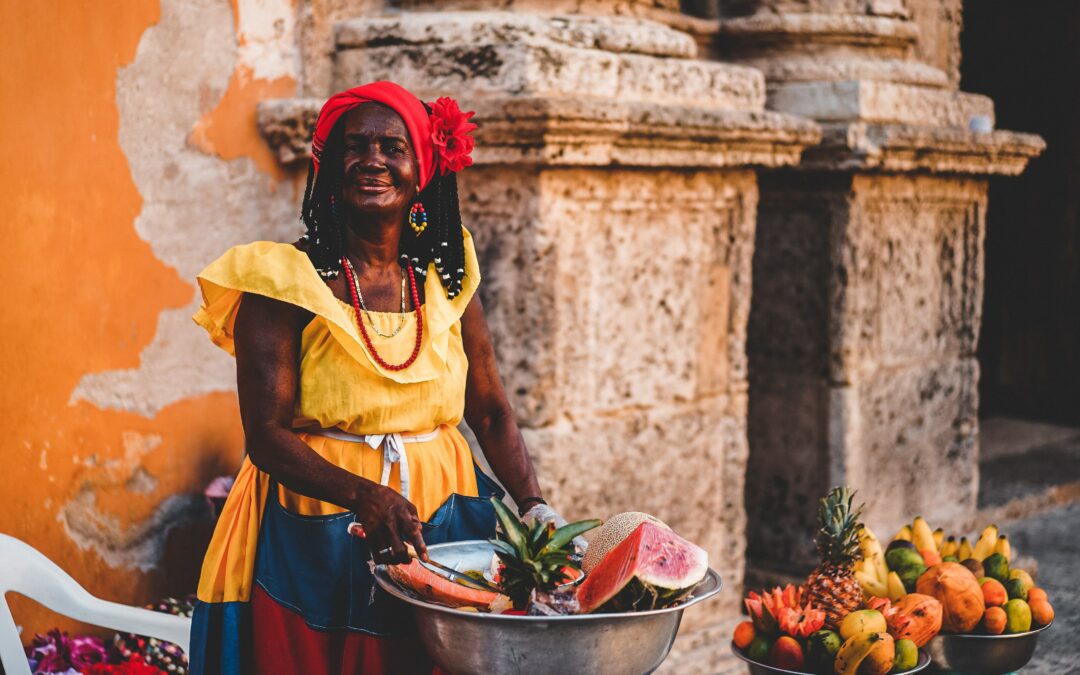 Colombian woman standing with a bucket of fruit