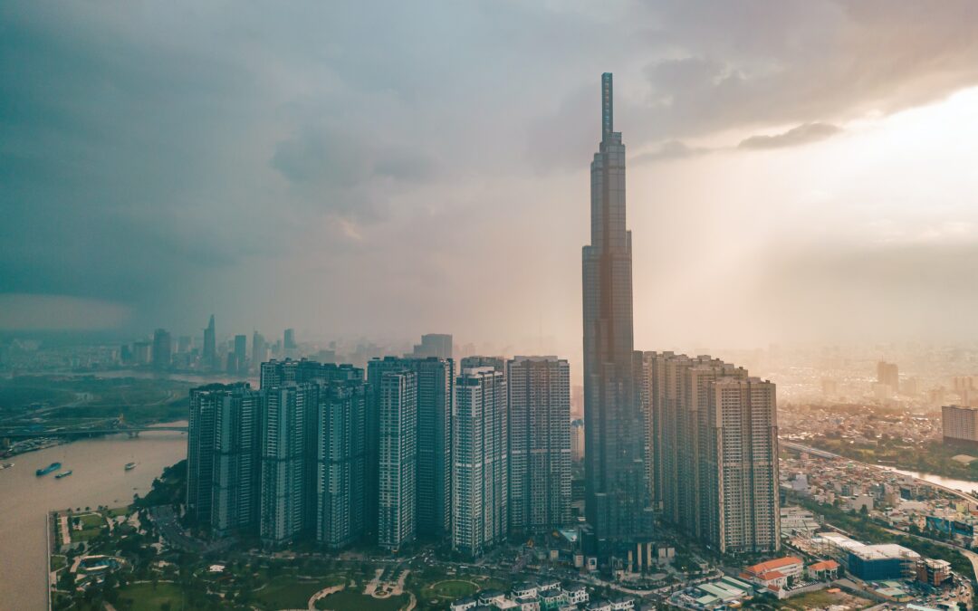 Picture of Vietnam economic center with high-rise building under a lot of clouds and a ray of sunlight seeping through and illuminating the city.